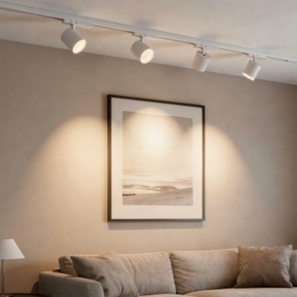 Traditional 3-phase track lighting system with prominent adjustable spotlights, shown installed in a comfortable modern residential bedroom.