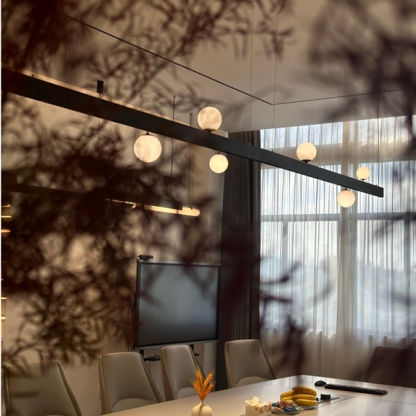 Standard magnetic track lighting system installed in a modern office meeting room, featuring a noticeable architectural line and integrated pendant lights.
